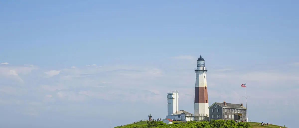 Montauk Point lighthouse on a green bluff above the ocean