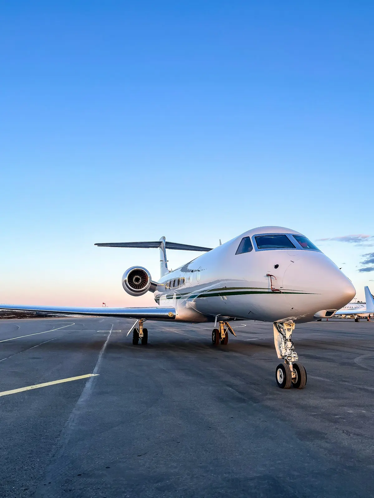 Large business jet parked on the ramp in early morning light
