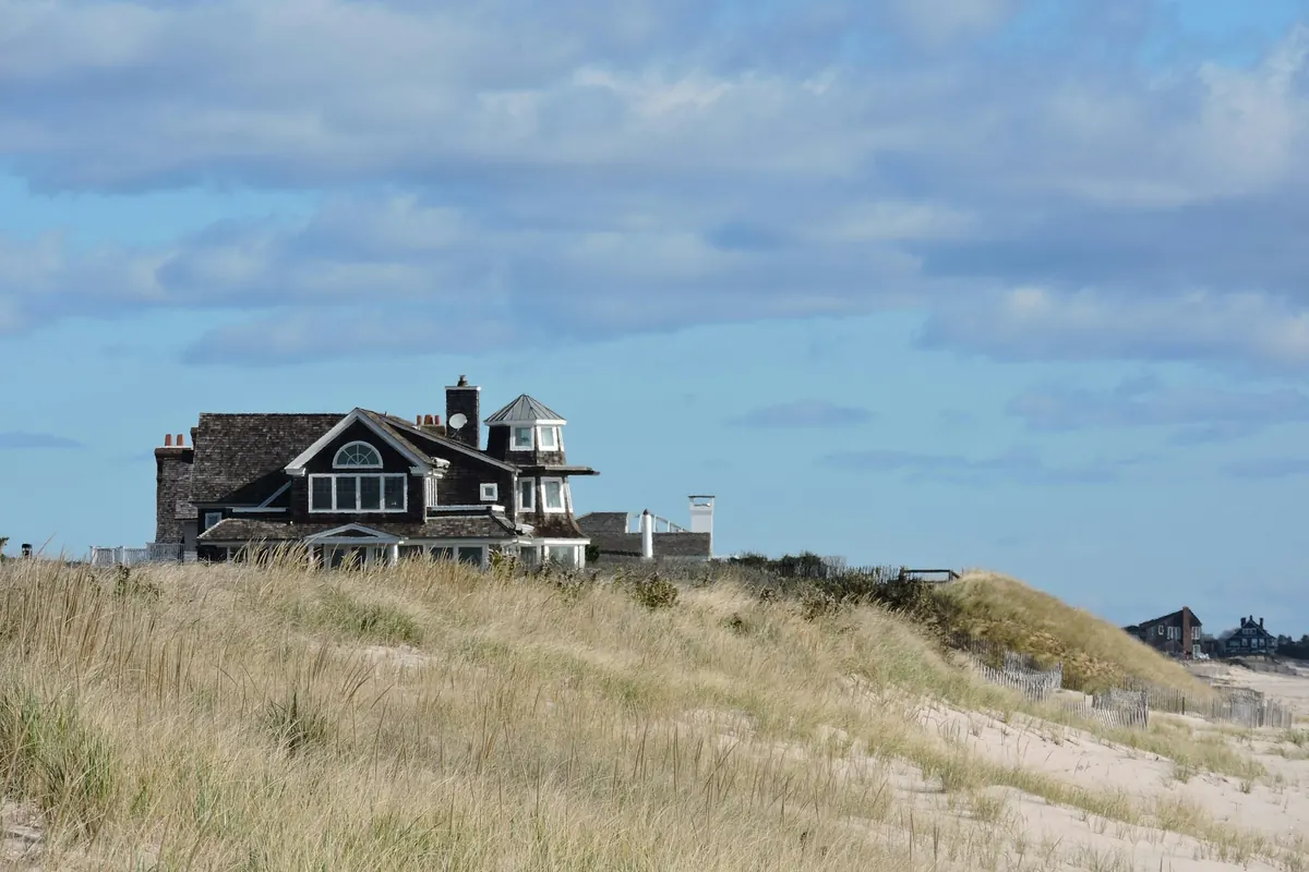 Shingled house above grassy dunes on the Atlantic coast